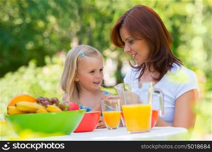 Mother and daughter picnicking at park or backyard