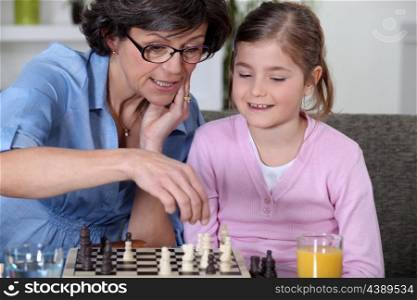 Mother and daughter playing chess.