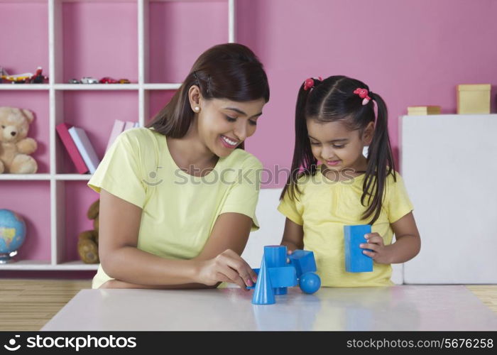 Mother and daughter playing with blocks at home