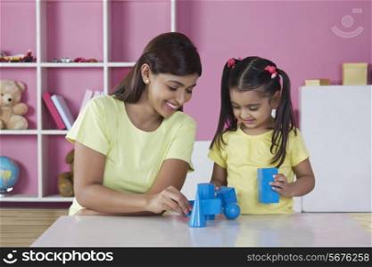 Mother and daughter playing with blocks at home
