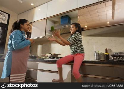 Mother and daughter playing with capsicum in the kitchen