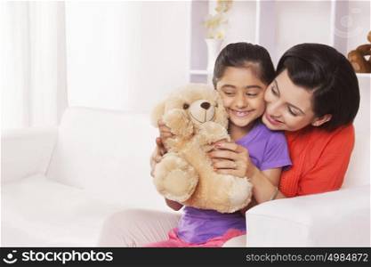 Mother and daughter playing with stuffed toy