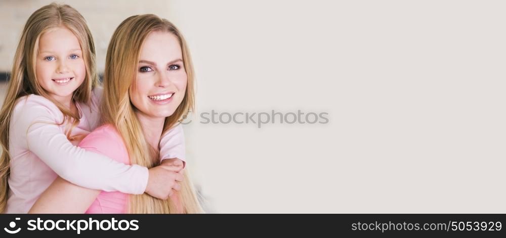 Mother and daughter. Portrait of beautiful young mother and daughter piggyback ride, photo with copy space