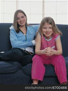 mother and daughter posing on a couch