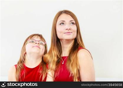 Mother and daughter posing together. Family relationships. Beauty mother with lovely daughter spending time together. Mommy and girl child wearing elegant clothes.