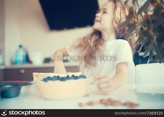 mother and daughter prepare a pie / home mom and daughter in kitchen bake a blueberry pie, the concept of family home cosiness