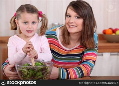 Mother and daughter preparing a salad.