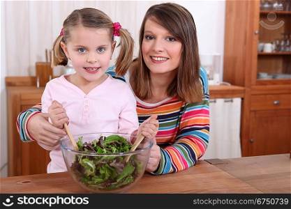 mother and daughter preparing a salad