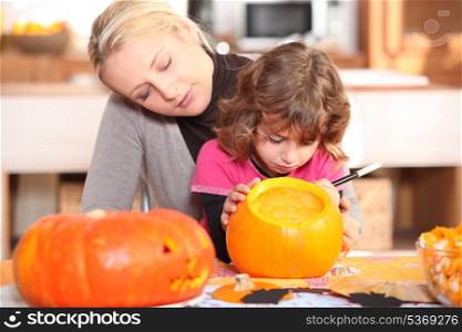 Mother and daughter preparing pumpkin in kitchen