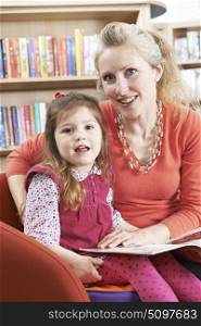 Mother And Daughter Reading Book In Library