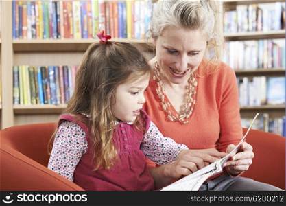 Mother And Daughter Reading Book In Library