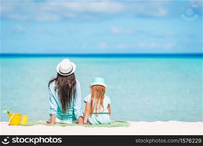 Mother and daughter relax on the beach. Beautiful mother and daughter at Caribbean beach enjoying summer vacation.