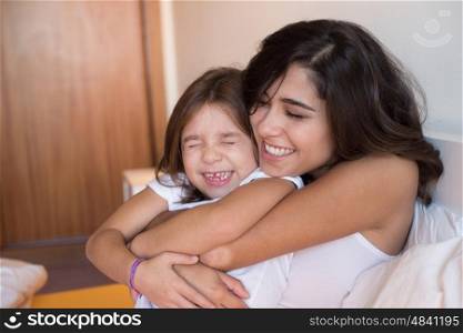 Mother and daughter relaxing in the bedroom
