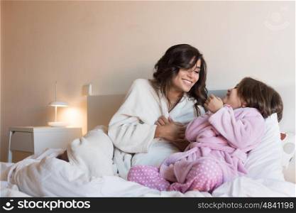 Mother and daughter relaxing in the bedroom