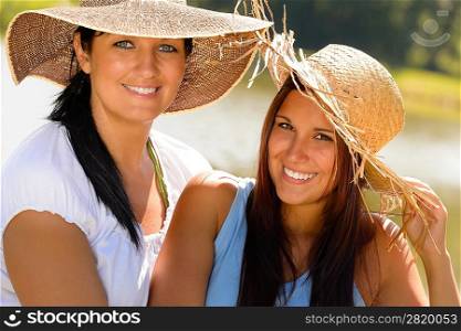 Mother and daughter relaxing outdoors summer teen vacation straw hats