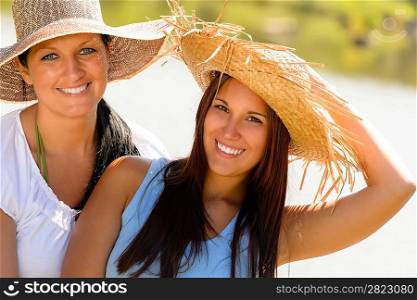 Mother and daughter relaxing outdoors summer teen vacation straw hats