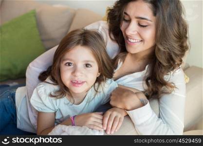 Mother and daughter relaxing together on couch