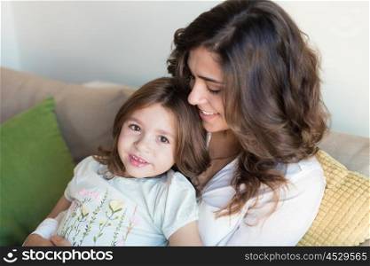 Mother and daughter relaxing together on couch
