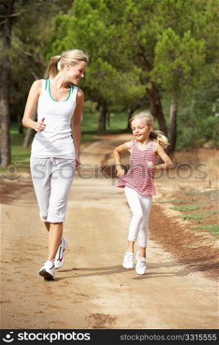 Mother and daughter running in park