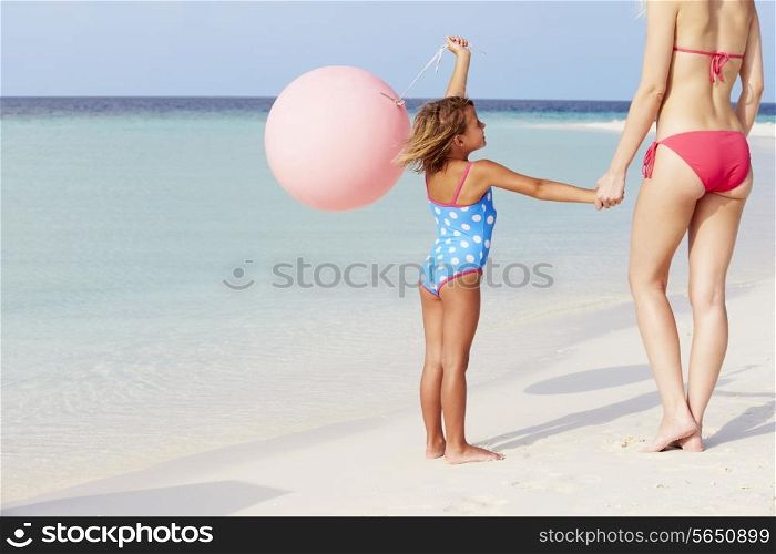 Mother And Daughter Running On Beautiful Beach With Balloon