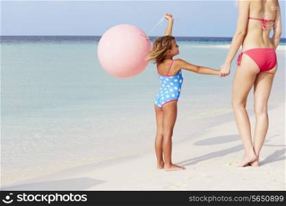 Mother And Daughter Running On Beautiful Beach With Balloon