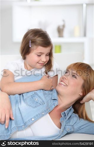 Mother and daughter sat on couch