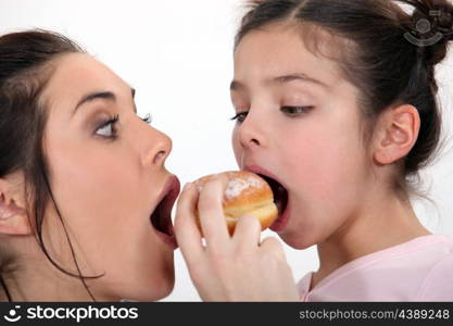 Mother and daughter sharing dough nut