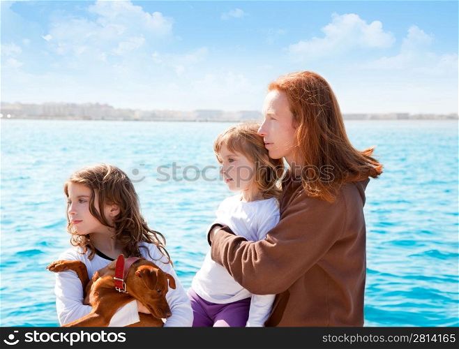 mother and daughter sister girls with dog on the sea sailing in a boat