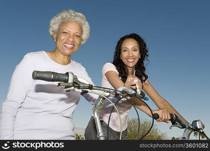 Mother and daughter sit on mountain bikes