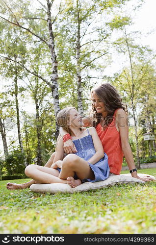 Mother and daughter sitting in garden