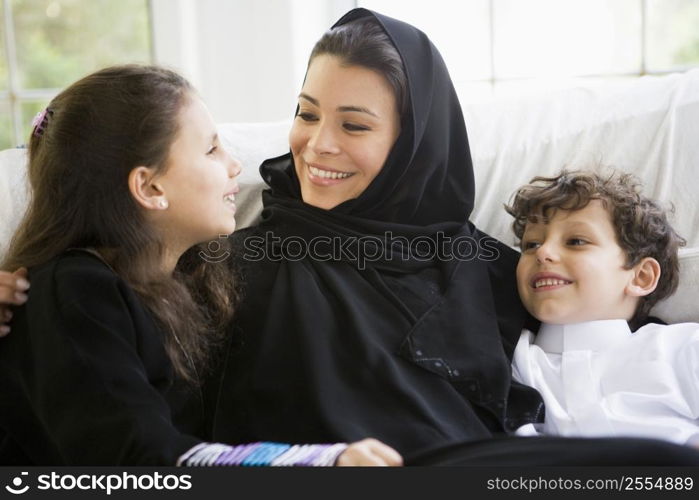 Mother and daughter sitting in living room smiling (high key/selective focus)