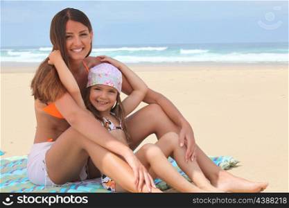 Mother and daughter sitting on a beach
