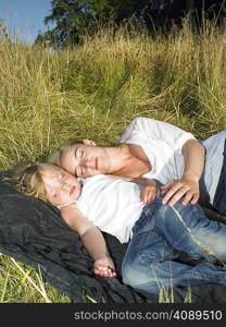 Mother and daughter sleeping in a field