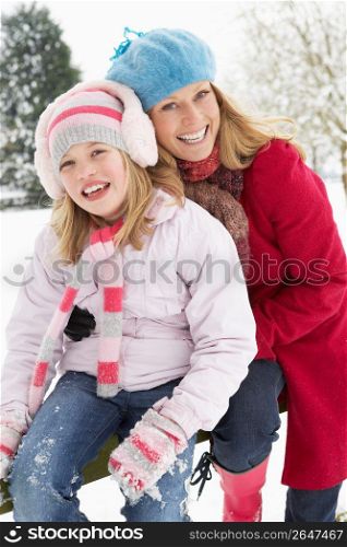 Mother And Daughter Standing Outside In Snowy Landscape