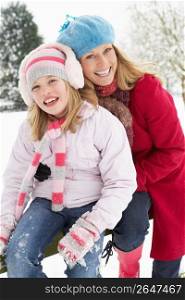 Mother And Daughter Standing Outside In Snowy Landscape
