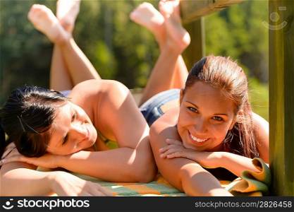 Mother and daughter sunbathing smiling teen friends togetherness leisure attractive