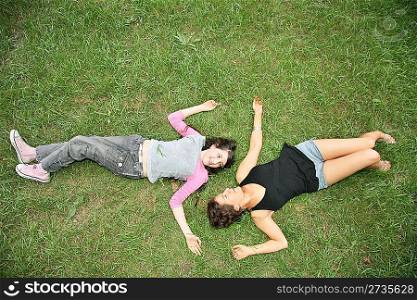 mother and daughter-teenager lie on the grass