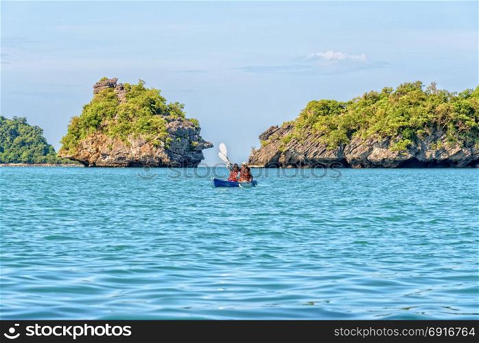 Mother and daughter travel by kayak. Two women are mother and daughter. Travel by boat with a kayak around island enjoy view the beautiful natural landscape of the blue sea at summer, Mu Ko Ang Thong National Park, Surat Thani, Thailand