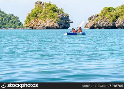 Mother and daughter travel by kayak. Two women are mother and daughter. Travel by boat with a kayak around island enjoy view the beautiful natural landscape of the blue sea at summer, Mu Ko Ang Thong National Park, Surat Thani, Thailand