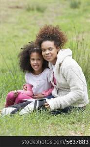Mother And Daughter Using Digital Tablet Countryside
