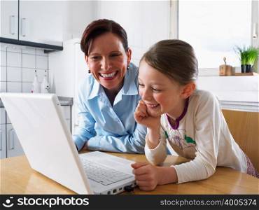 Mother and daughter using laptop computer