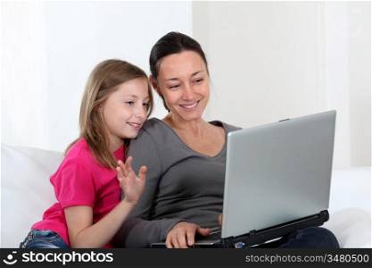 Mother and daughter using laptop computer at home