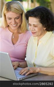 Mother and Daughter Using Laptop on Patio
