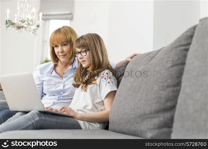 Mother and daughter using laptop together at home