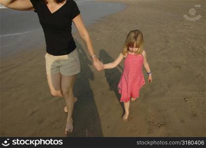 Mother and Daughter walking down beach
