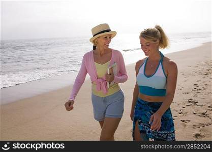 Mother and daughter walking on beach