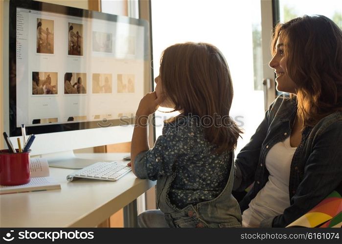 Mother and daughter watching their photos on computer