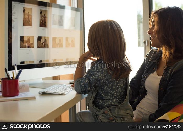 Mother and daughter watching their photos on computer