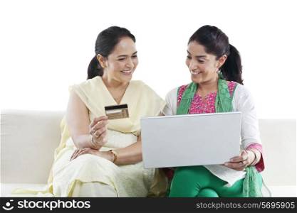 Mother and daughter with a laptop and credit card