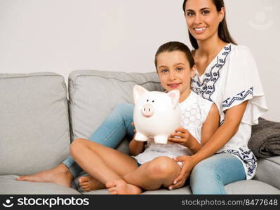 Mother and daughter with a piggy bank for her future savings